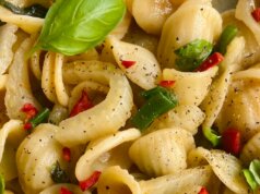 a close up of a plate of pasta with basil