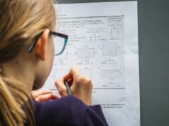 woman in black framed eyeglasses holding pen