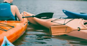 person riding on orange kayak during daytime