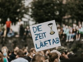 a protest with a sign that says die zeit lauftab
