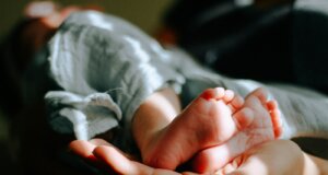 person holding baby feet
